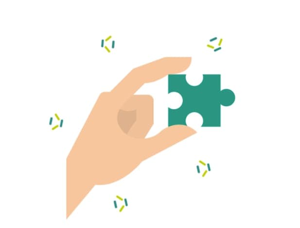 A hand holding a single jigsaw puzzle piece