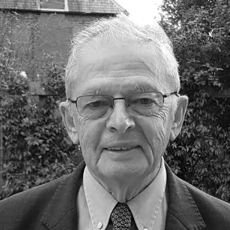 Stuart Montgomery in a suit, standing in a garden