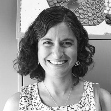 Susanne Ahmari, smiling to camera in a patterned top