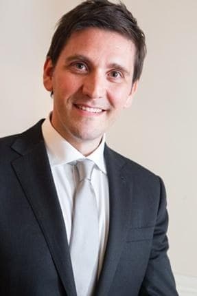 Vincenzo Garzya in a suit and tie, looking to camera